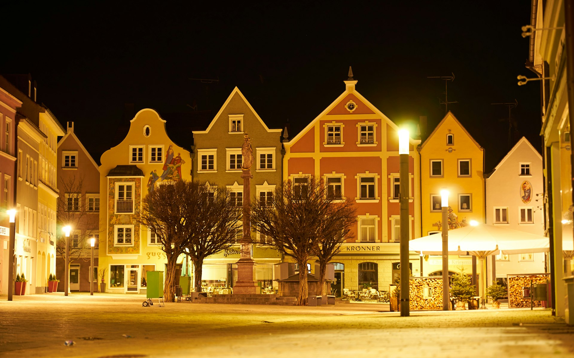 a city street at night with a row of buildings